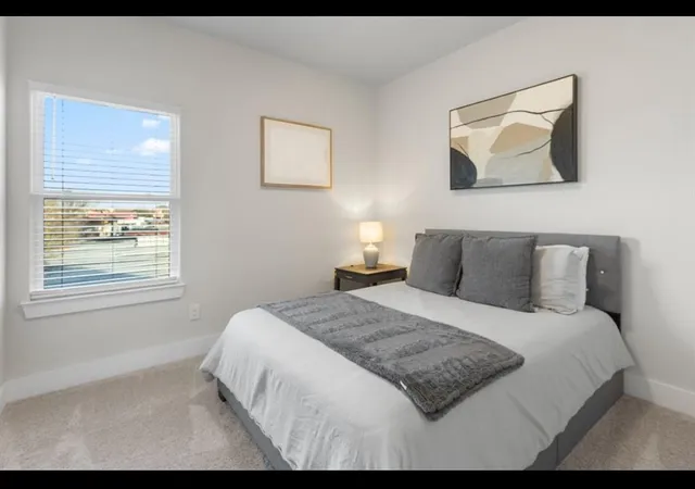 a bedroom with a bed and a painting on the wall