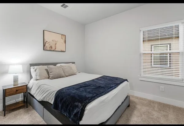a large bed sitting in a bedroom next to a window