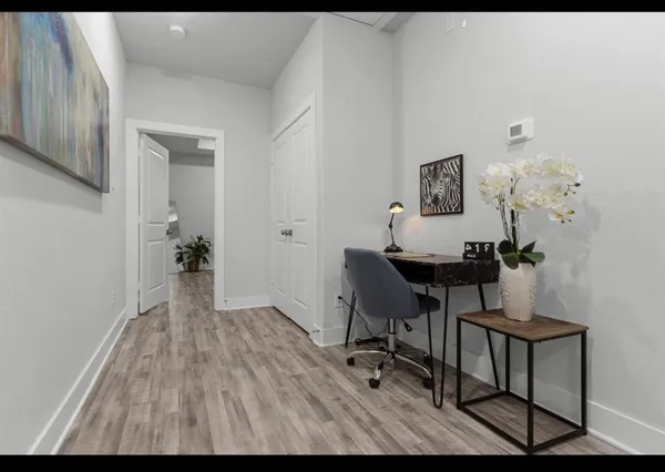 a view of a workspace with furniture and a window