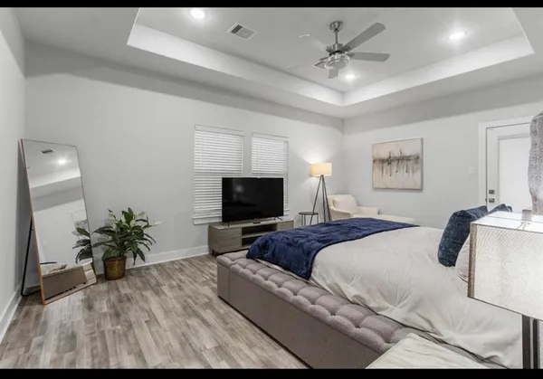 a spacious bedroom with a bed and a flat screen tv