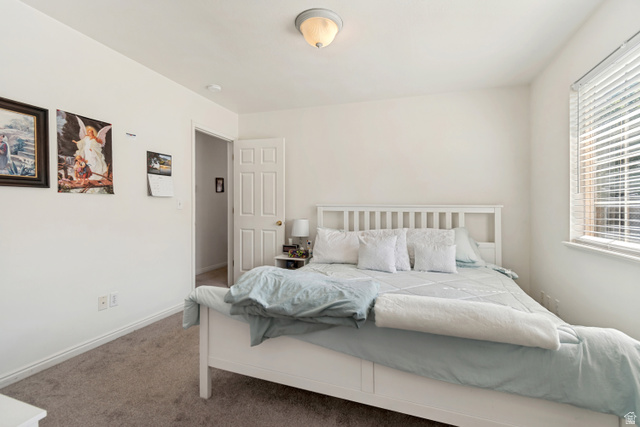 254 North 700 East Santaquin, UT 84655 - Photo 7 of 15 Carpeted bedroom featuring white walls, a single window with horizontal blinds, a white paneled door, and an overhead flush-mount light fixture