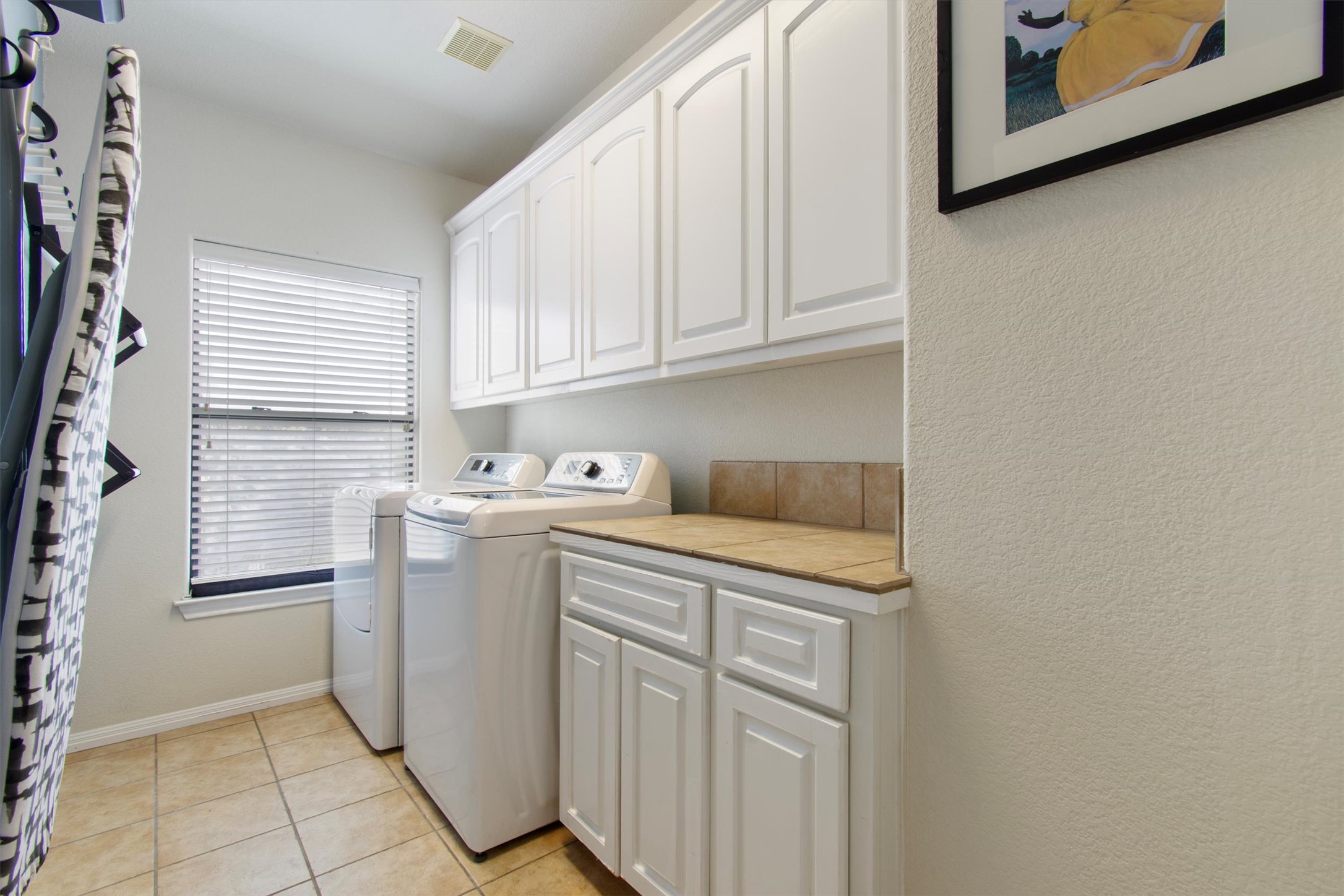 6 Monarch Oaks Lane Austin, TX 78738 - Photo 28 of 40 Laundry area featuring cabinet space, light tile patterned floors, and washer and clothes dryer