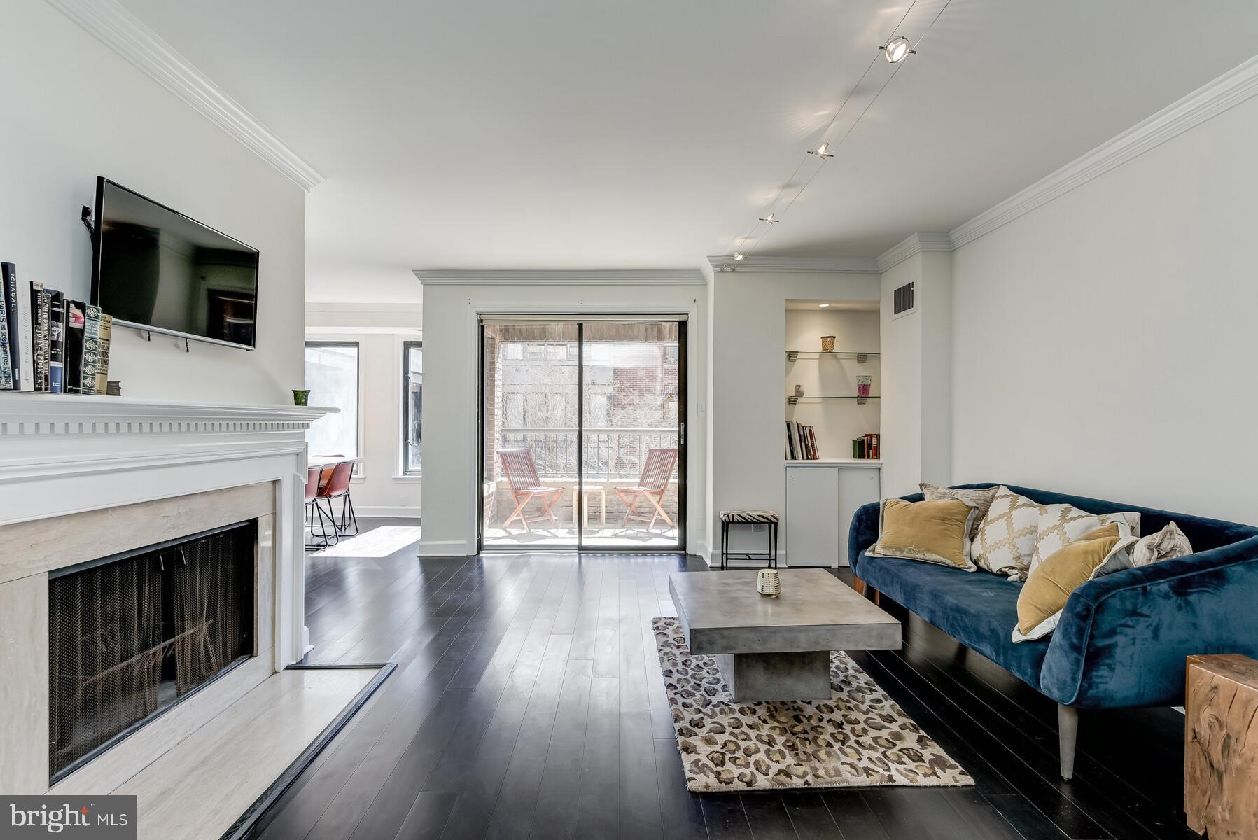 1080 Wisconsin Avenue Northwest, Unit 2001 Washington, DC 20007 - Photo 1 of 30 a living room with furniture and a fireplace