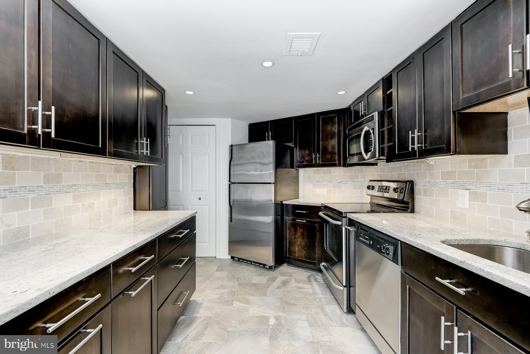 1080 Wisconsin Avenue Northwest, Unit 2001 Washington, DC 20007 - Photo 13 of 30 a kitchen with stainless steel appliances granite countertop a sink stove and refrigerator