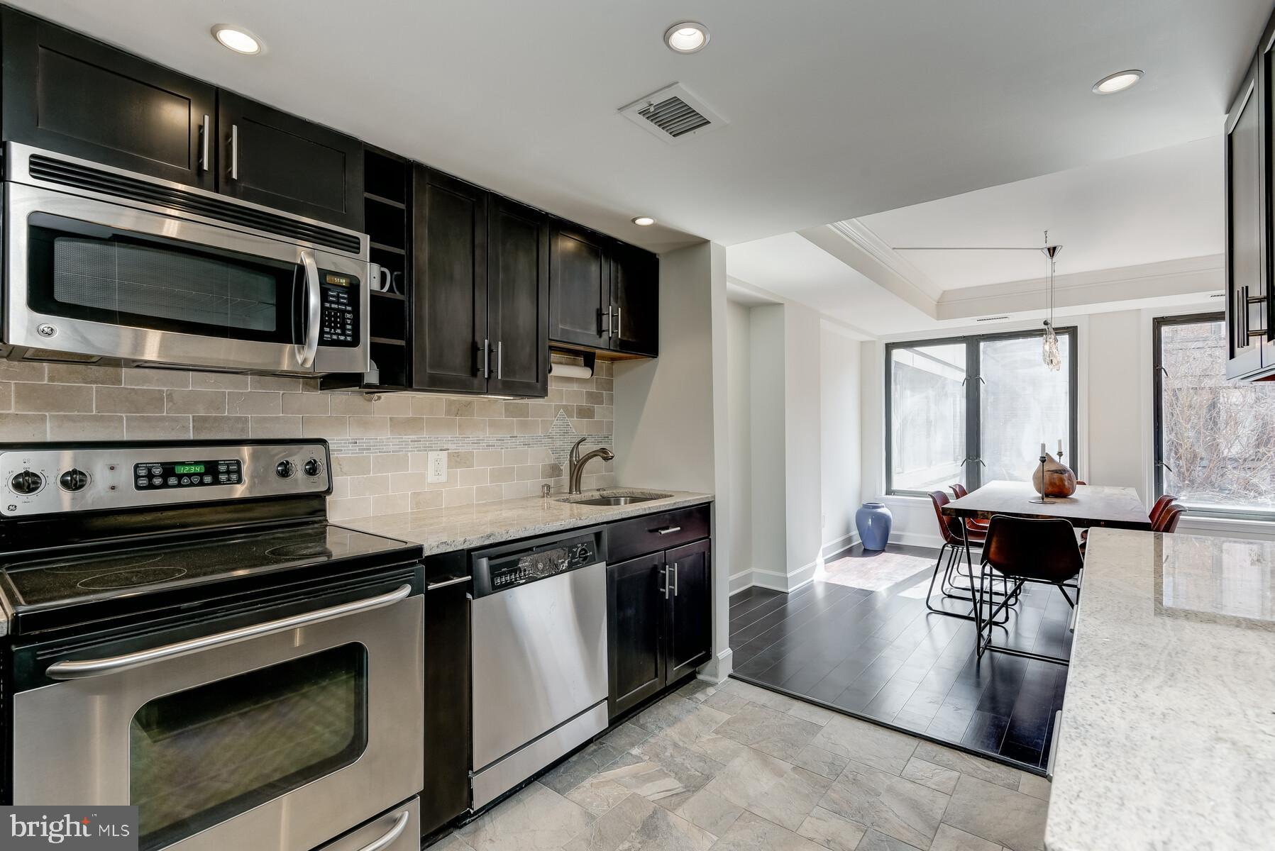 1080 Wisconsin Avenue Northwest, Unit 2001 Washington, DC 20007 - Photo 14 of 30 a kitchen with stainless steel appliances kitchen island granite countertop a stove and a sink