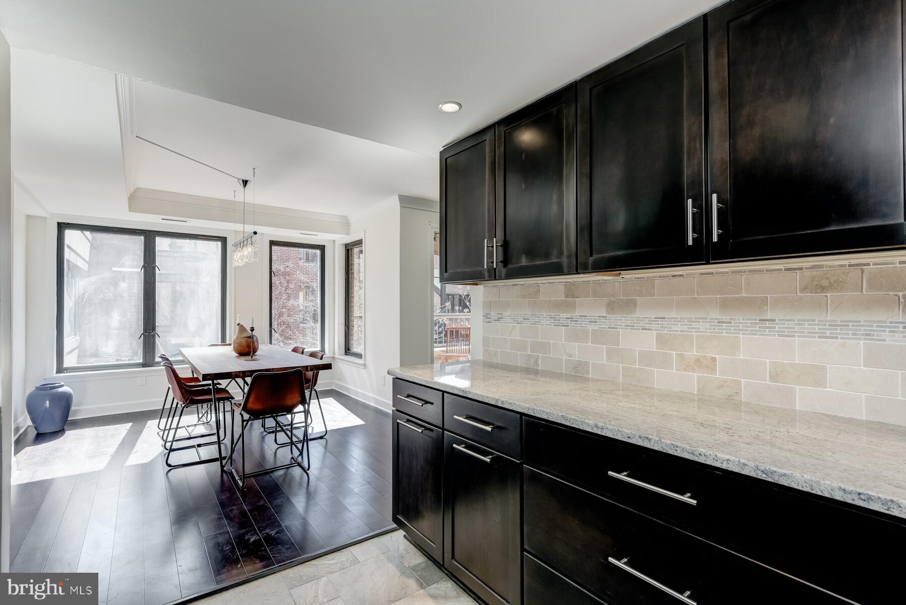 1080 Wisconsin Avenue Northwest, Unit 2001 Washington, DC 20007 - Photo 15 of 30 a kitchen with stainless steel appliances kitchen island granite countertop a sink and cabinets