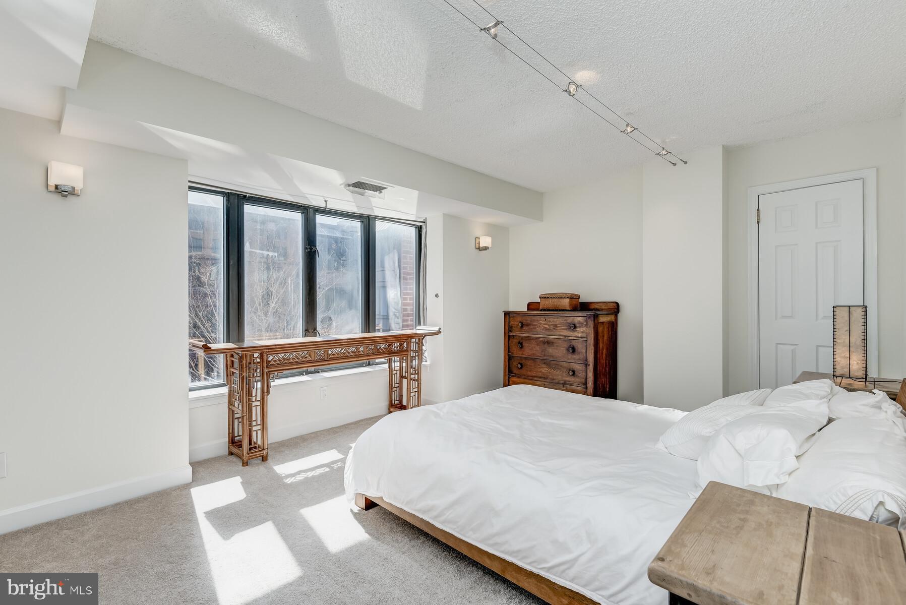1080 Wisconsin Avenue Northwest, Unit 2001 Washington, DC 20007 - Photo 17 of 30 a bedroom with a large bed and a large window