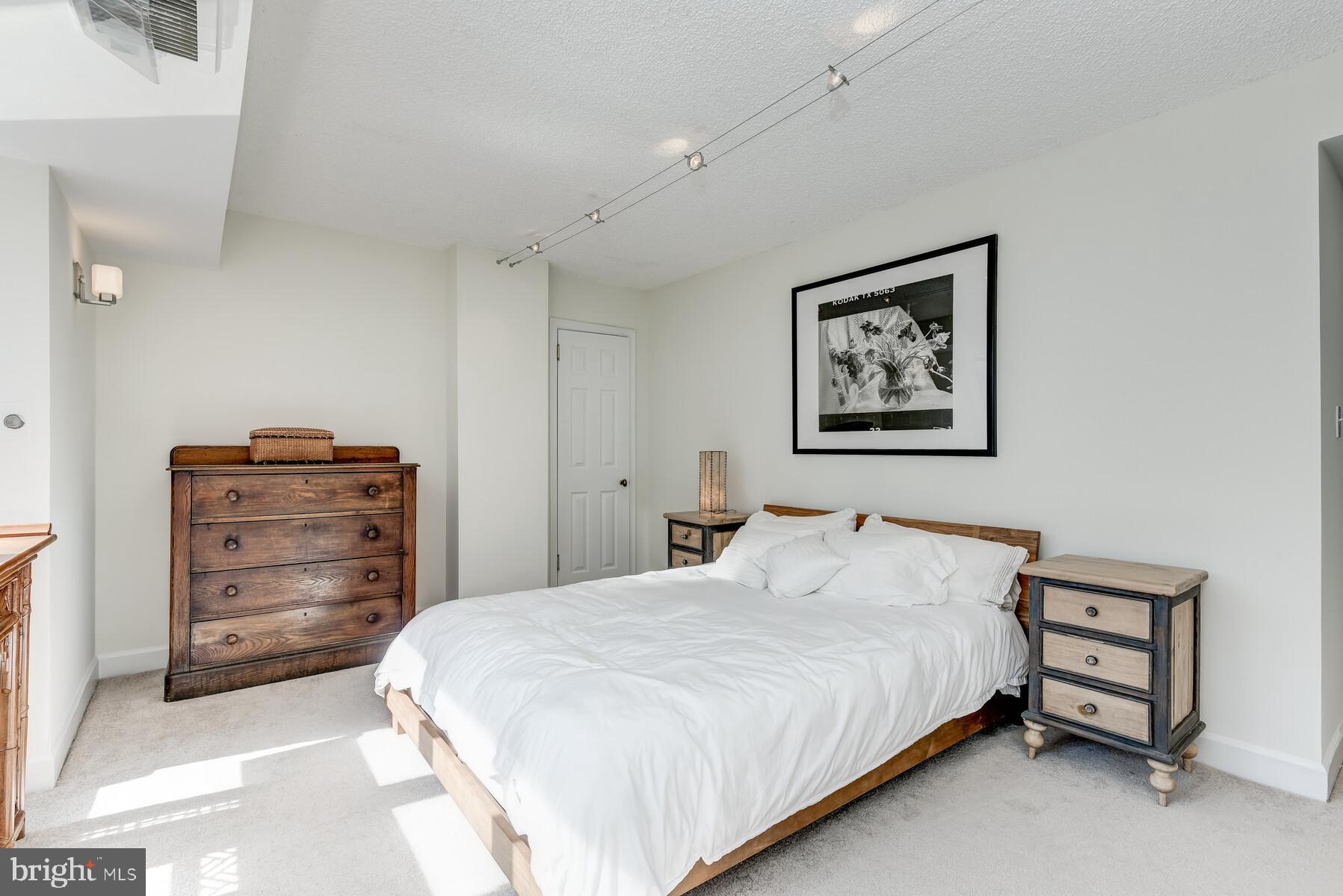 1080 Wisconsin Avenue Northwest, Unit 2001 Washington, DC 20007 - Photo 18 of 30 a bedroom with a bed and a dresser