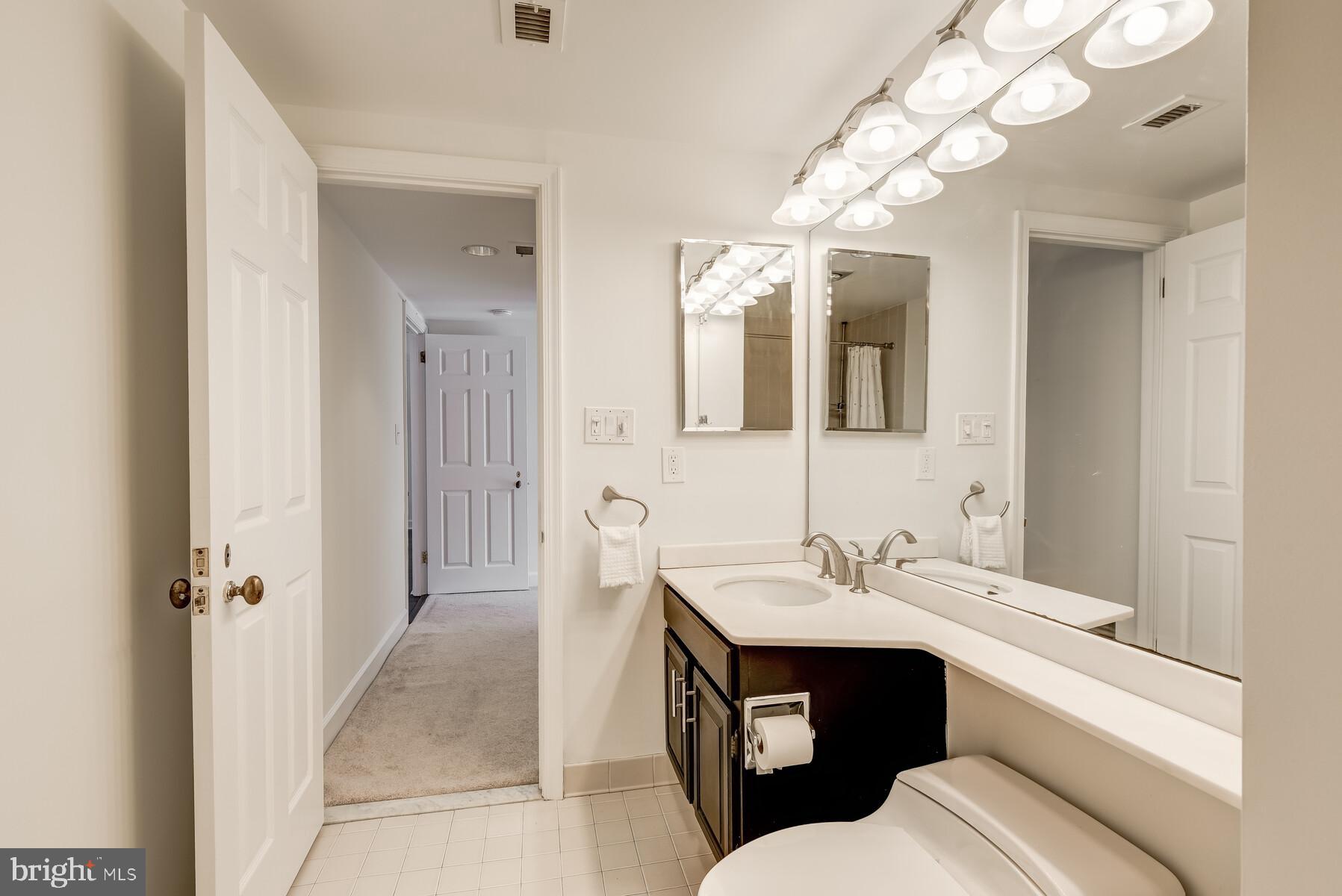 1080 Wisconsin Avenue Northwest, Unit 2001 Washington, DC 20007 - Photo 22 of 30 a bathroom with a sink a toilet and a mirror