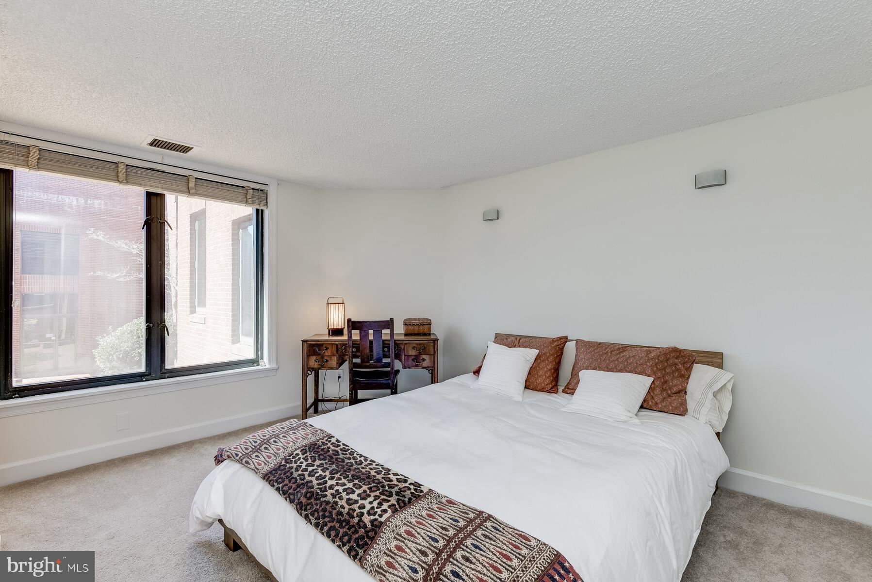 1080 Wisconsin Avenue Northwest, Unit 2001 Washington, DC 20007 - Photo 23 of 30 a bedroom with a large bed and wooden floor
