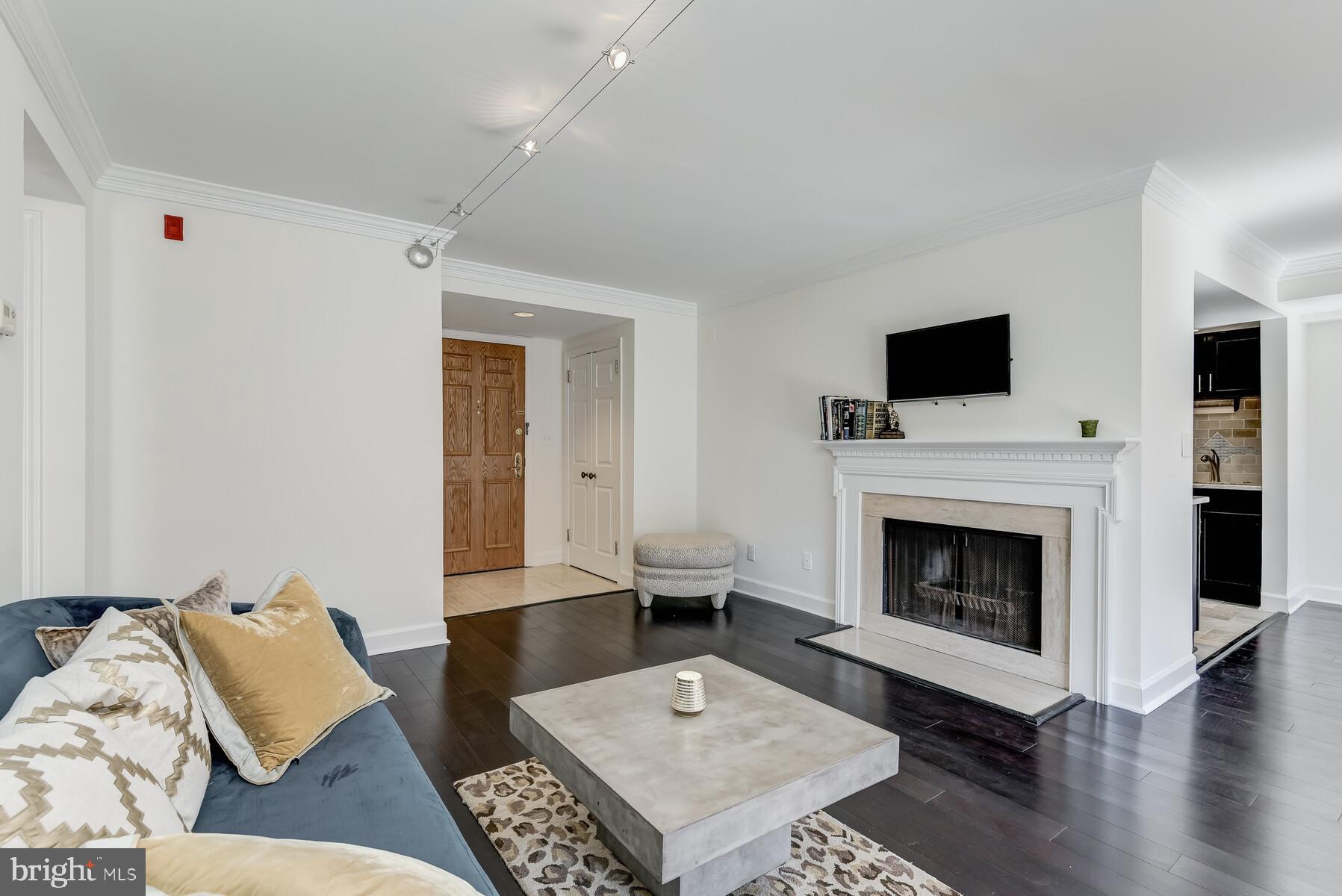 1080 Wisconsin Avenue Northwest, Unit 2001 Washington, DC 20007 - Photo 8 of 30 a living room with furniture a flat screen tv and a fireplace