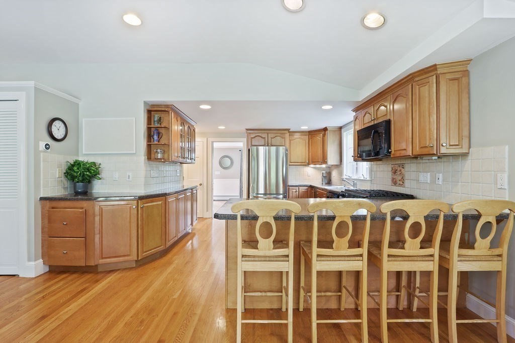 28 Appleton Road Needham, MA 02492 - Photo 6 of 24 a large white kitchen with wooden floor and stainless steel appliances