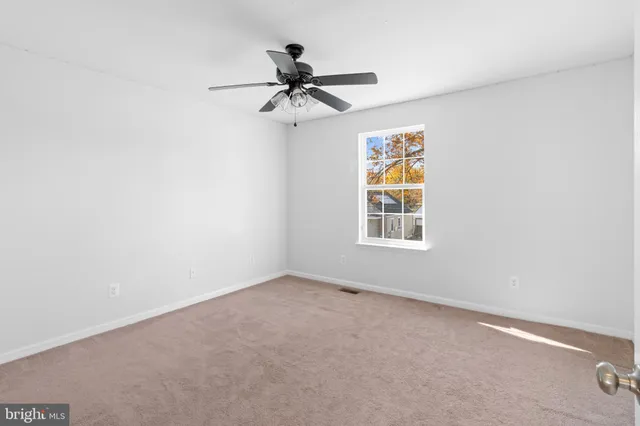 a view of room with ceiling fan and window