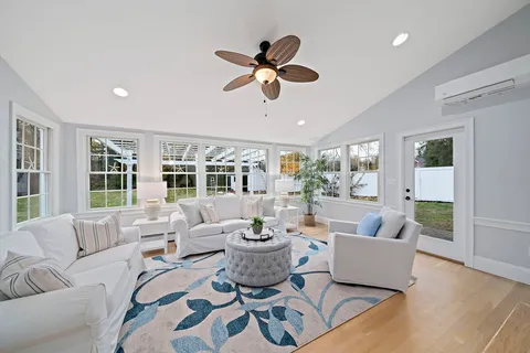 a living room with furniture ceiling fan and a window