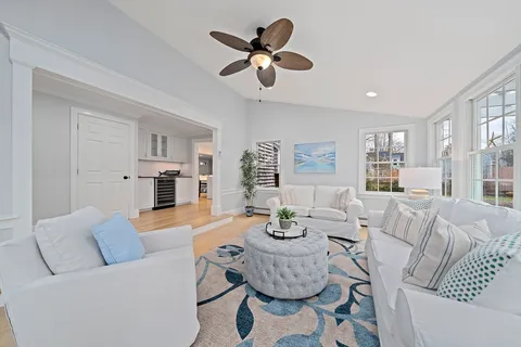 a living room with furniture and view of kitchen