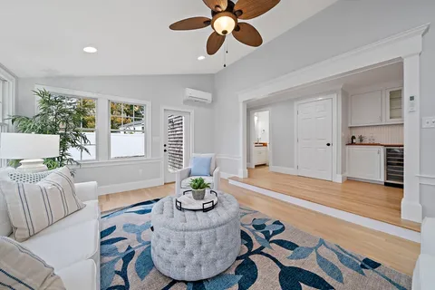 a living room with furniture and a wooden floor