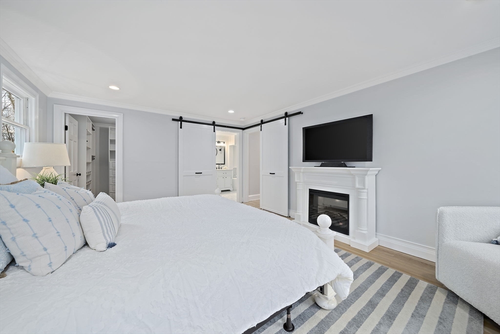 309 South Main Street Cohasset, MA 02025 - Photo 19 of 35 a bed room with a bed a fireplace and a television