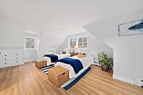 a bed room with two beds and a potted plant