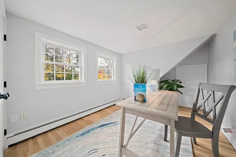 a workspace room with furniture and a potted plant