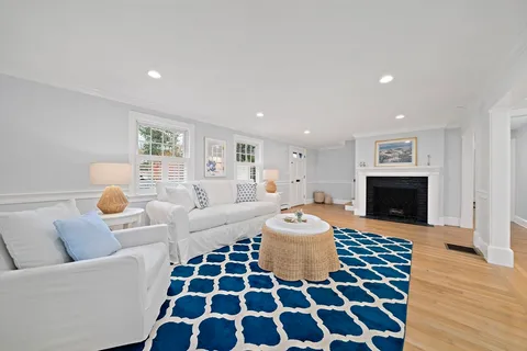 a living room with furniture a fireplace and a window
