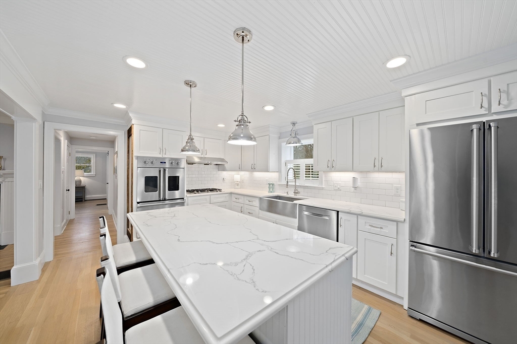 309 South Main Street Cohasset, MA 02025 - Photo 6 of 35 a large kitchen with kitchen island a stove a sink a refrigerator and a view of living room
