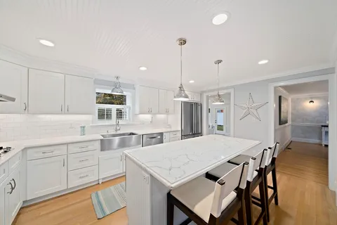 a kitchen with a table chairs refrigerator and cabinets