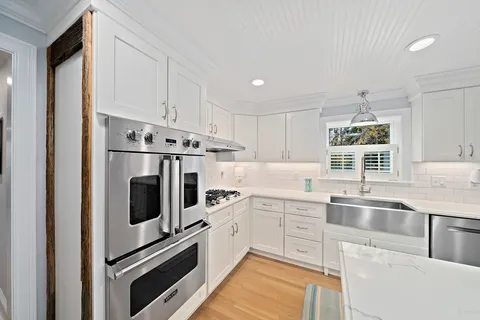 a kitchen with white cabinets and white appliances