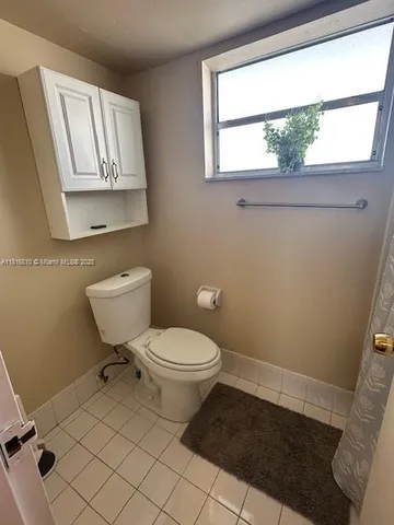 a bathroom with a toilet a sink and a window