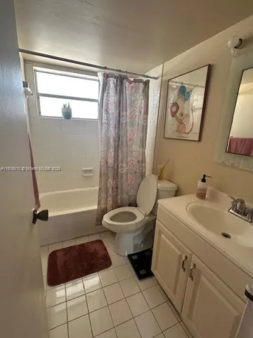a bathroom with a toilet a sink a mirror a window and vanity