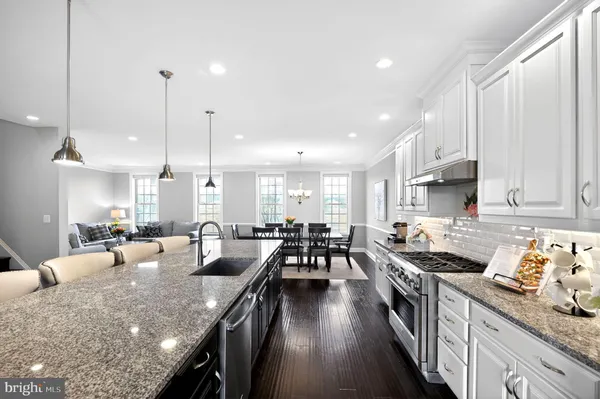 a large kitchen with lots of counter space a sink dining table and chairs