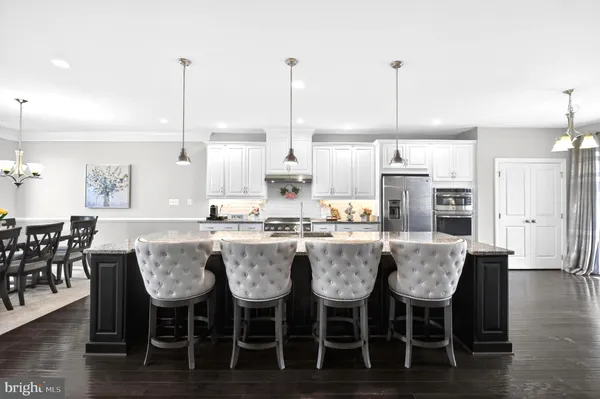 a dining table with chairs and kitchen view