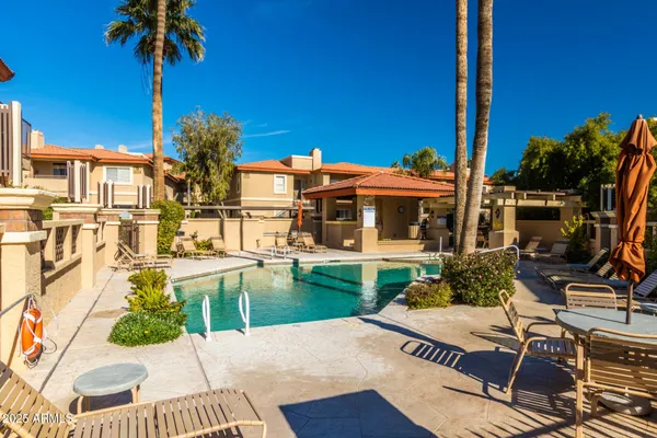 a view of a patio with table and chairs potted plants and palm tree