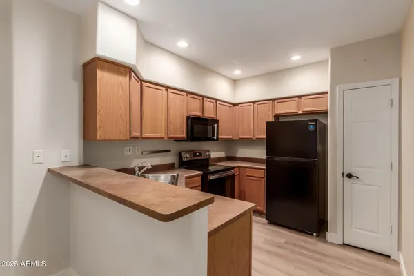 a kitchen with stainless steel appliances granite countertop a refrigerator a stove a sink and a microwave