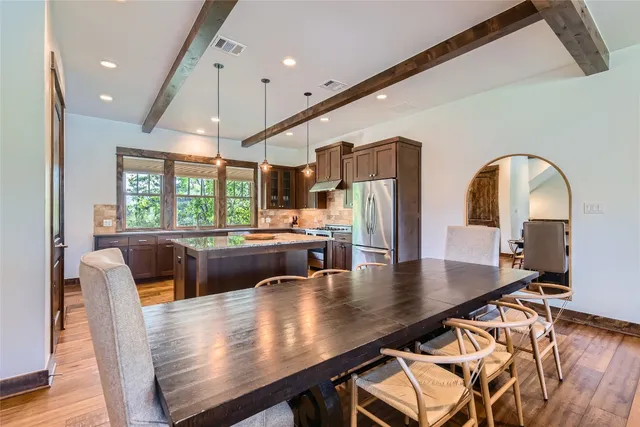 a view of a dining room with furniture a chandelier and wooden floor