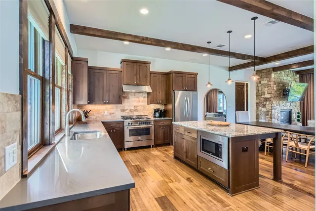 a kitchen with stainless steel appliances granite countertop a stove oven and a refrigerator