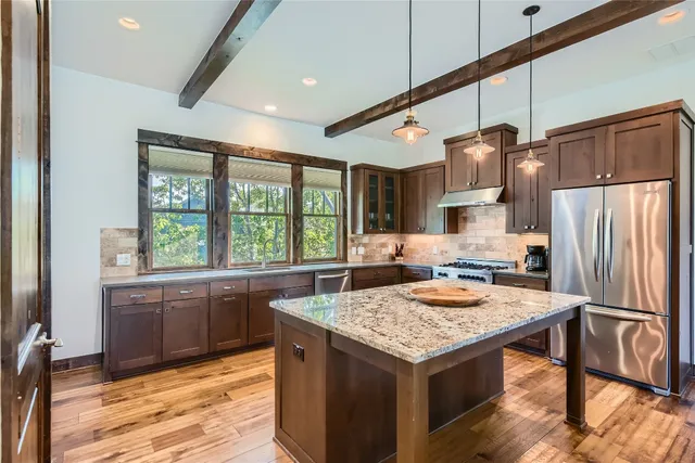 a kitchen with a stove a refrigerator and a stove top oven