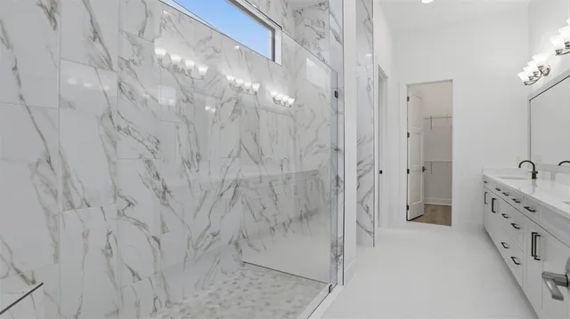 a bathroom with a double vanity sink and shower