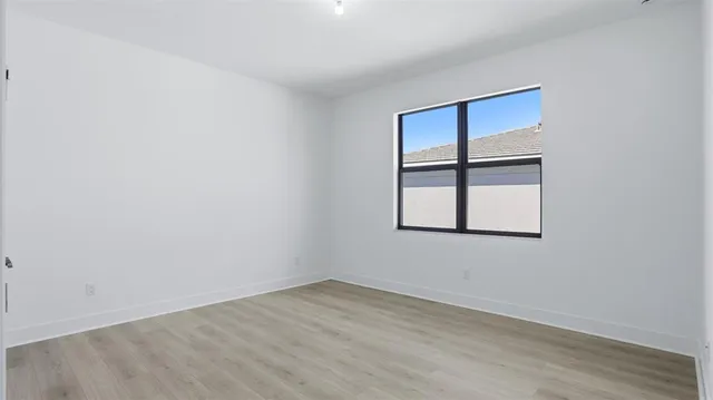 wooden floor in an empty room with a window