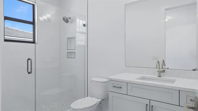 a bathroom with a sink a toilet and shower