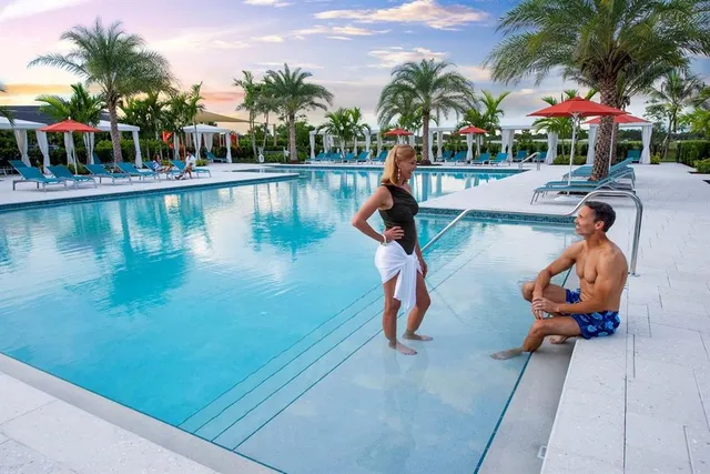 a view of a swimming pool with a bench and lawn chairs