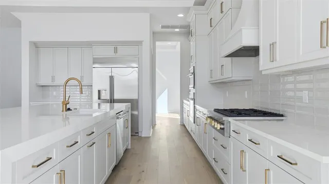 a kitchen with stainless steel appliances a sink stove and cabinets