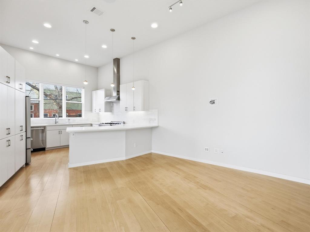 2802 Lee Street Dallas, TX 75206 - Photo 11 of 40 a large kitchen with a large counter top a sink stainless steel appliances and cabinets