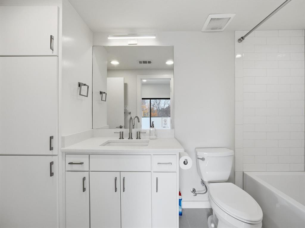 2802 Lee Street Dallas, TX 75206 - Photo 27 of 40 a bathroom with a sink a toilet a mirror and vanity