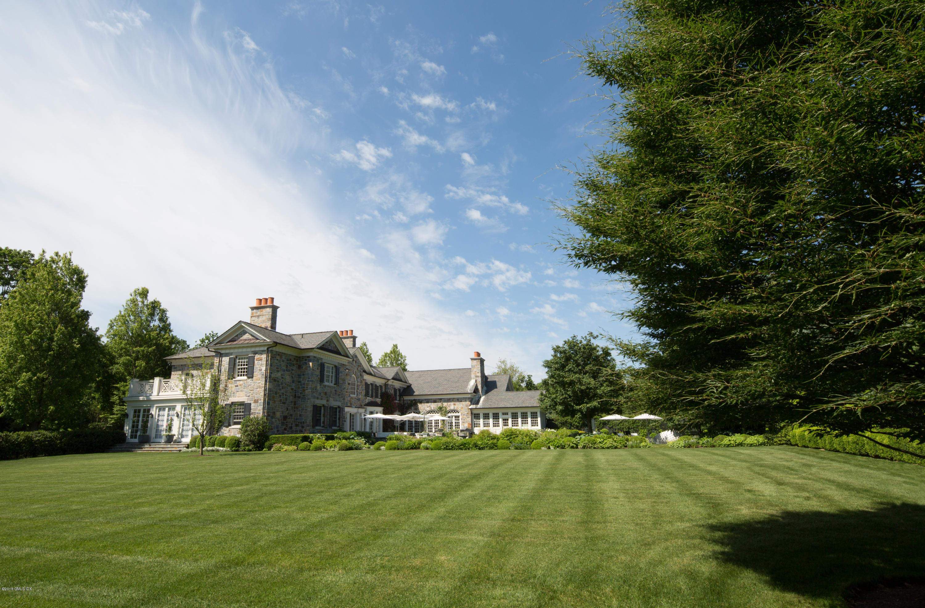2 Deer Park Meadow Road Greenwich, CT 06830 - Photo 24 of 28 a view of a big house with a big yard and large trees