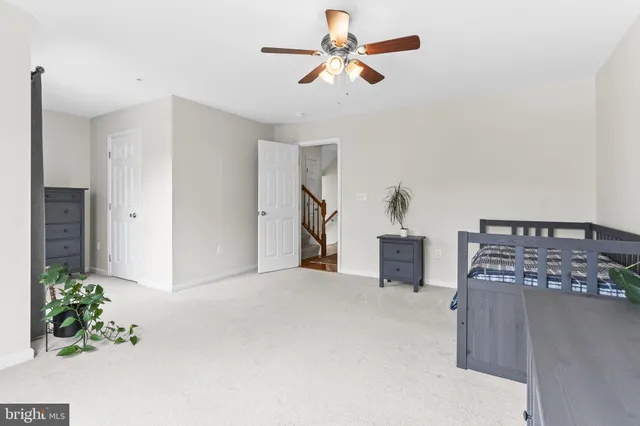 a bedroom with a bed chair and wooden floor