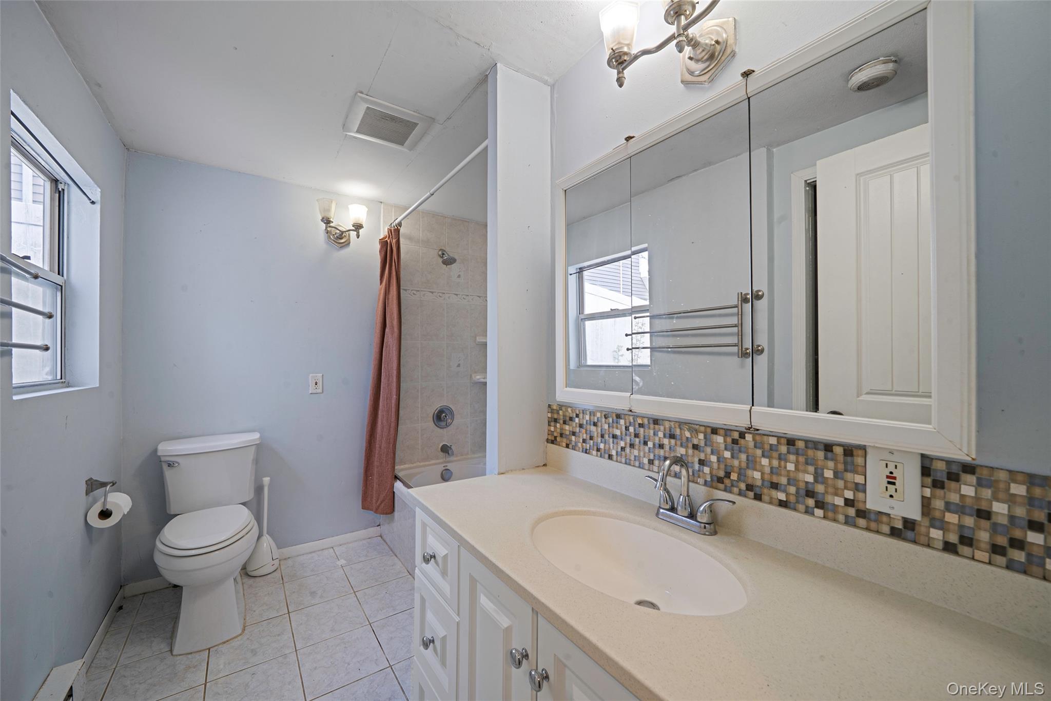 93 Maple Road Kings Park, NY 11754 - Photo 18 of 24 a bathroom with a sink a toilet and shower