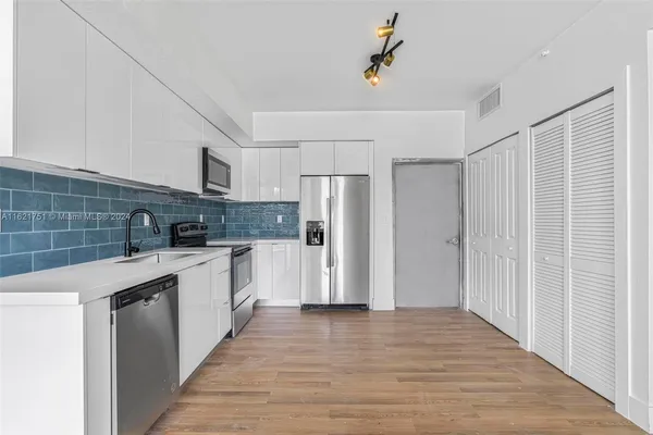 a kitchen with stainless steel appliances a refrigerator and a sink