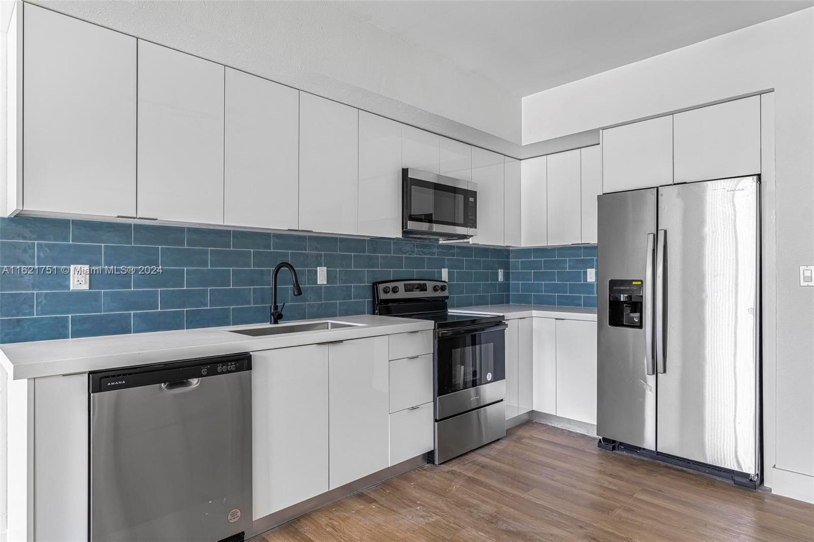 16955 Southwest 100th Avenue Miami, FL 33157 - Photo 15 of 36 a kitchen with stainless steel appliances granite countertop a refrigerator sink and stove