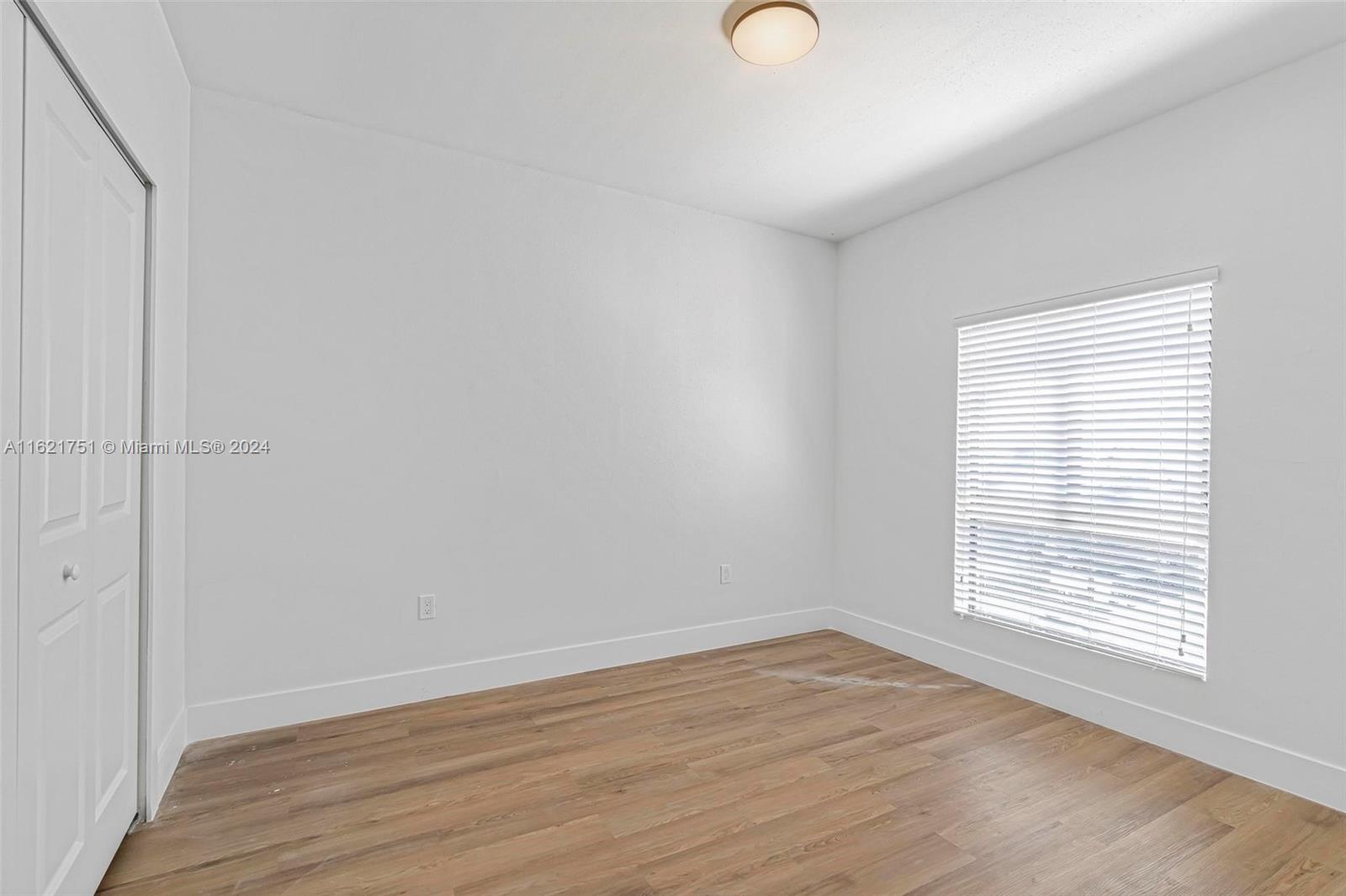 16955 Southwest 100th Avenue Miami, FL 33157 - Photo 19 of 36 a view of an empty room with wooden floor and a window