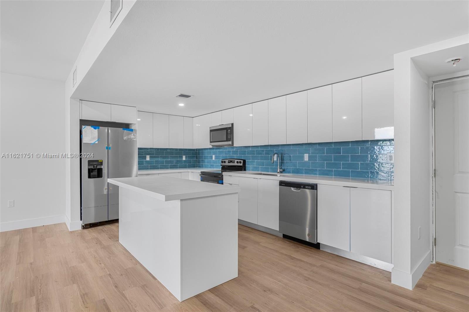16955 Southwest 100th Avenue Miami, FL 33157 - Photo 20 of 36 a kitchen with white cabinets and white appliances